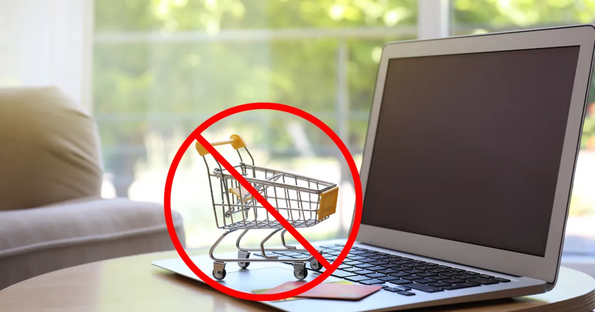 Áthúzott bevásárlókocsi egy laptop előtt, az online vásárlás hiányát jelképezve